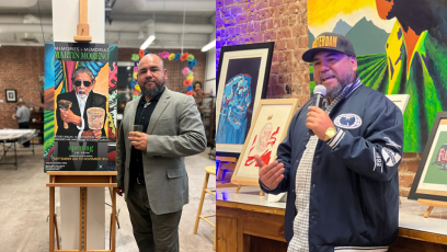 Phoenix College alumnus Francisco Garcia stand next to and talks about his art work. 