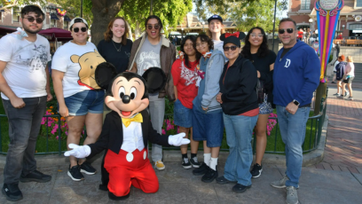 Phoenix College honors students take a picture with Mickey Mouse at Disneyland with Program Director Kenny Miller and Program Advisor Safia Sampson