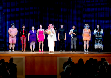 Phoenix College adjunct faculty and fashion show producer Naomi Ellis stands in front of Fashion Production students on the stage of Bulpitt Auditorium after the 2023 fashion show Vie d'Ours Chique