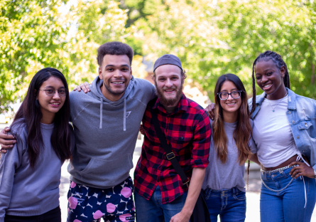 Photo of five PC students arm in arm on campus