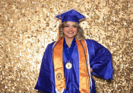 PC graduate, Ingrid in blue and gold Commencement regalia