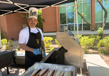 PC Staff, Michael Matos, grills up hotdogs for students