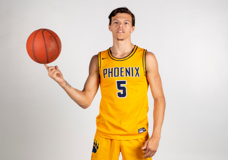 Phoenix College alumnus Jamar Brown spins a basketball on his finger.  