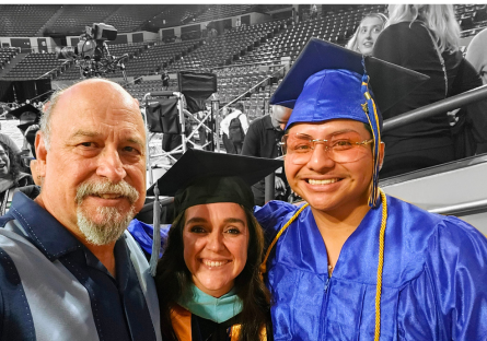 Jesse Lopez Martin posing in graduation regalia with two alumni after 2025's commencement ceremony