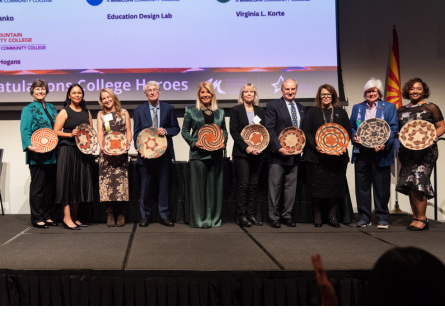 10 College Heroes lined up on stage holding their honor award