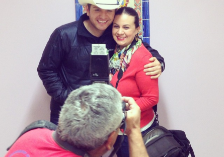José Muñoz taking photo of man in cowboy hat with lady (red sweater and scarf)