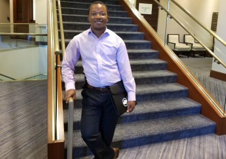 Isaac Batu walking down the stairs as a PC student
