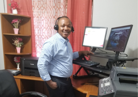 Isaac Batu standing at his desk working from home