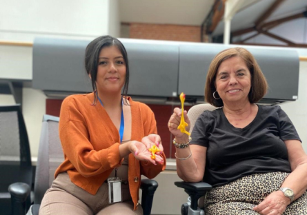 PC staff members holding up two rubber chicken