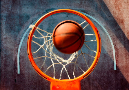Basketball going through net of hoop over street court 