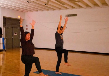 Phoenix College yoga instructor Ashley Burns demonstrates a yoga pose to Phoenix College student Woong Yu