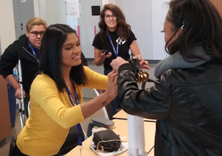 Phoenix College alumna Sandra Quiroz assists another student at a Phoenix College STEM outreach event