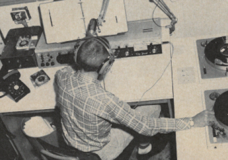 A student in Phoenix College's radio station in the 1950s with microphone, two turntables and other equipment