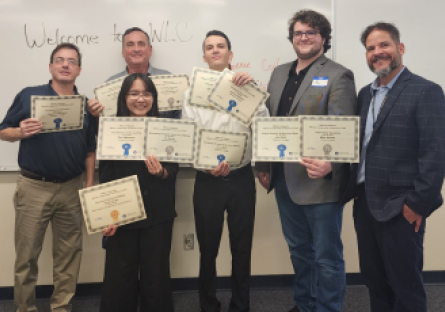 Members and advisors of Phoenix College's Future Business Leaders of American (FBLA) collegiat club hold up the eleven awards won by the team at the Winter Leadership Conference