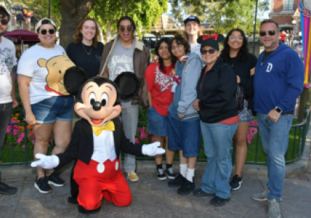 Phoenix College honors students take a picture with Mickey Mouse at Disneyland with Program Director Kenny Miller and Program Advisor Safia Sampson