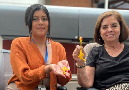 PC staff members holding up two rubber chicken