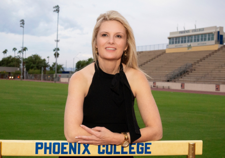 Dr. Kimberly Britt standing behind a track hurdle at Hogan Field